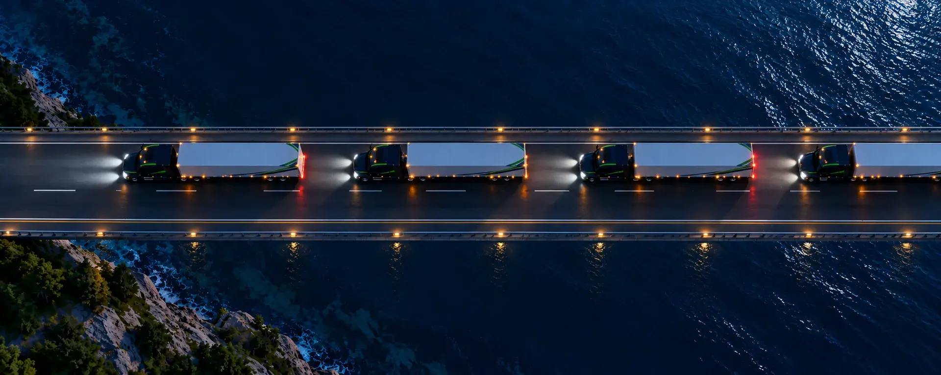 A line of tractor-trailers crossing a bridge over the sea